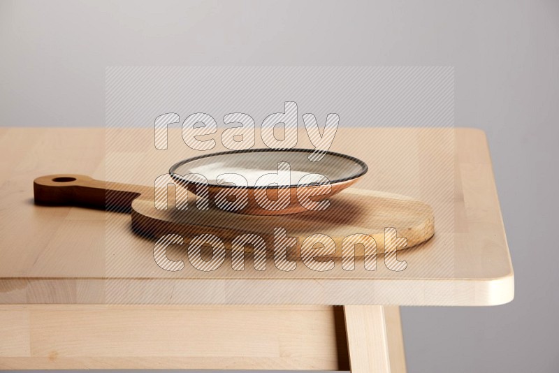multi colored plate placed on a  wooden oval cutting board on the edge of wooden table