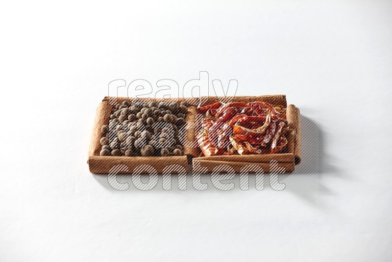2 squares of cinnamon sticks full of dried red chilis and allspice on white flooring