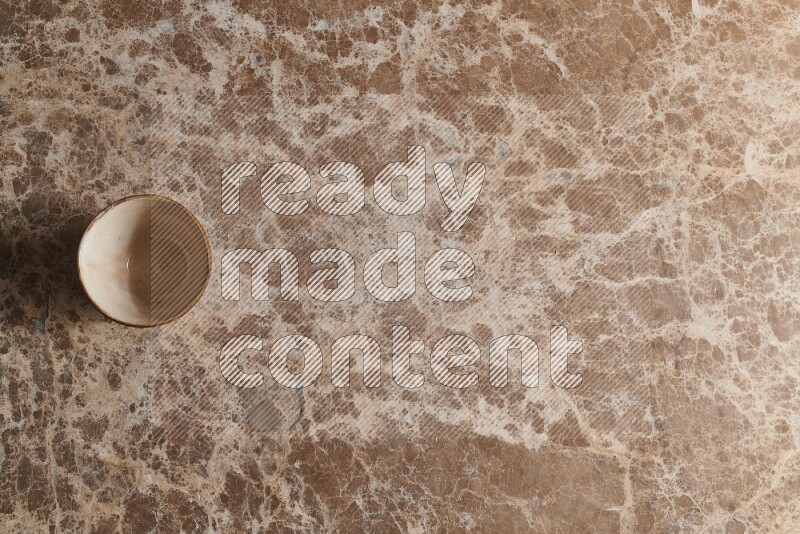 A white pottery bowl on beige marble background