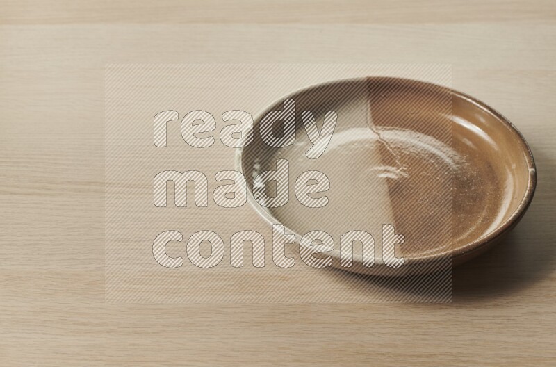 A multicolored pottery plate on light wooden background