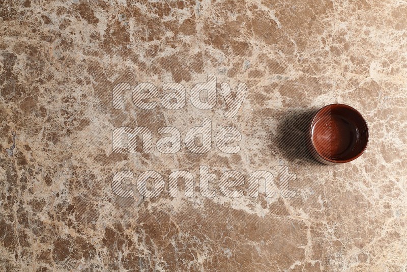 Top View Shot Of A Brown Pottery bowl On beige Marble Flooring