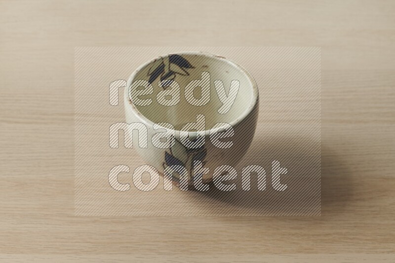 A decorative pottery bowl on light wooden background