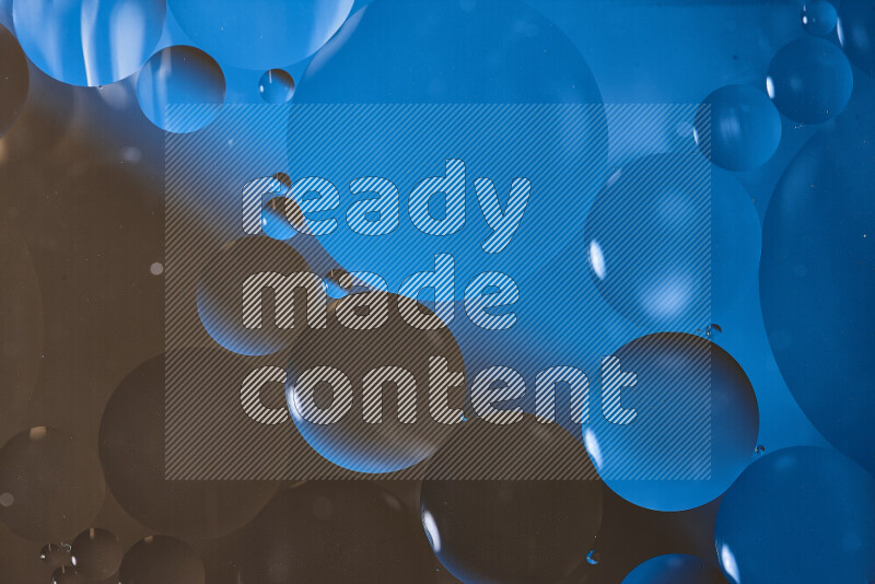 لقطات مقربة لفقاعات من الزيت على سطح الماء باللون الأزرق والبني