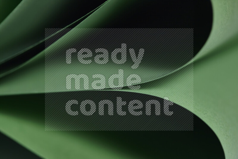 An abstract art showing green paper sheets arranged in an overlapping curves
