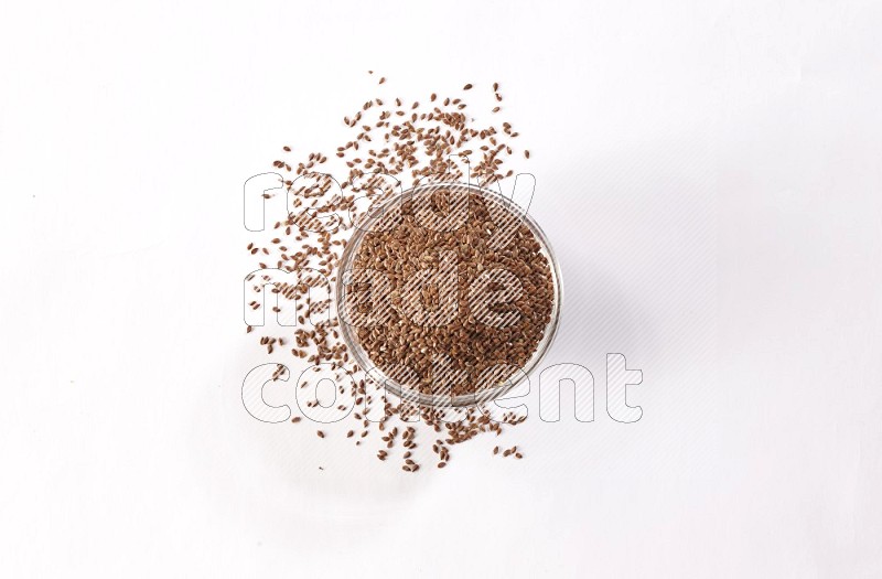 A glass bowl full of flax surrounded by flax seeds on a white flooring in different angles