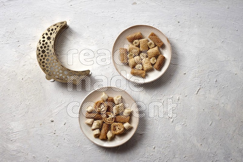 Oriental sweets in pottery plates with a lantern in a light setup