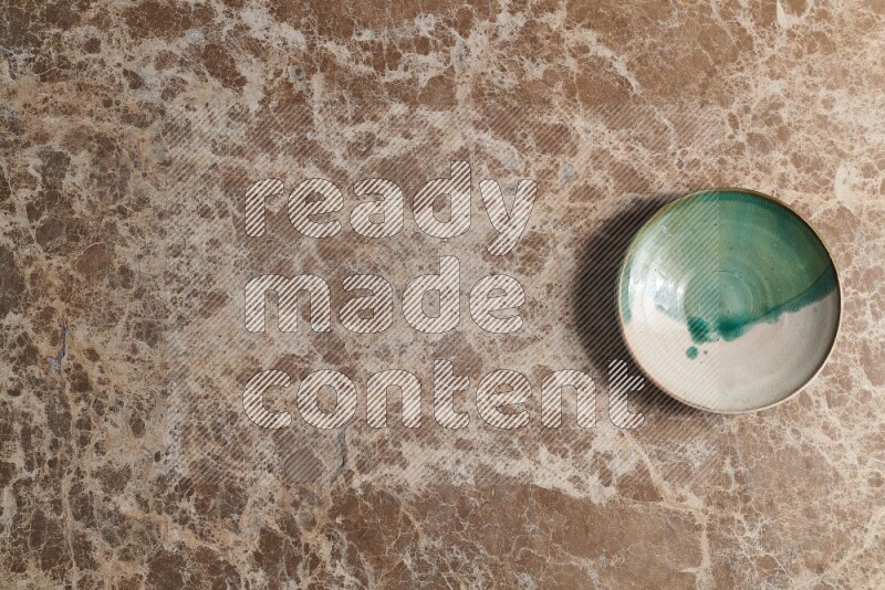 A decorative pottery plate on beige marble background