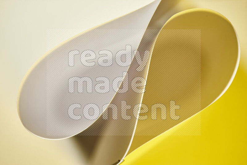 An abstract art of paper folded into smooth curves in white and yellow gradients
