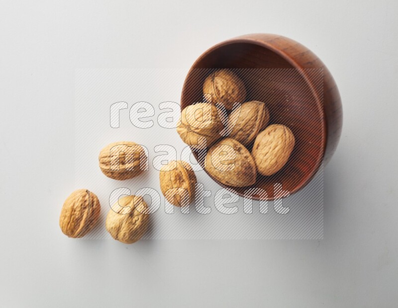 Top-view shot of walnut in a container on white background