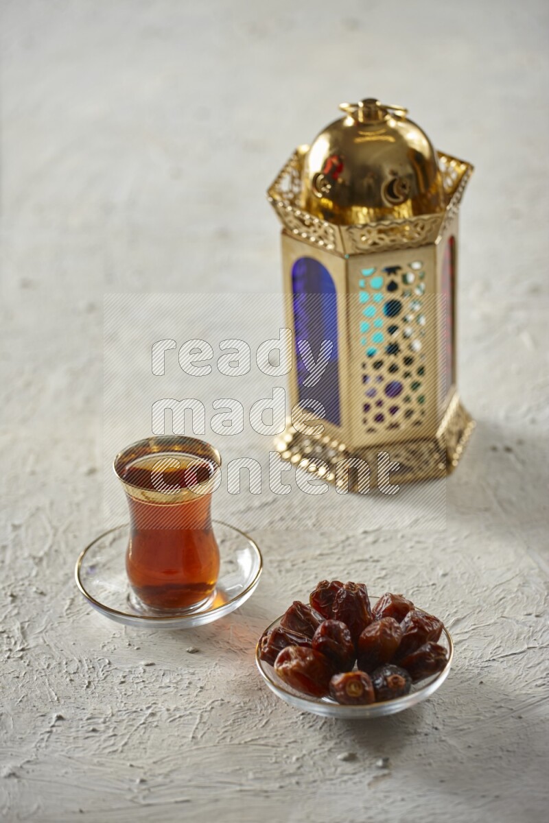 A golden lantern with different drinks, dates, nuts, prayer beads and quran on textured white background