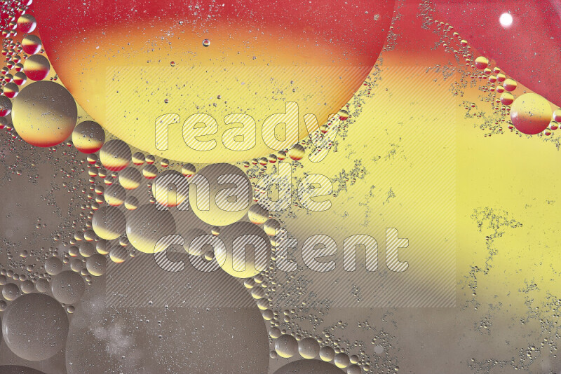 Close-ups of abstract oil bubbles on water surface in shades of yellow, red and brown