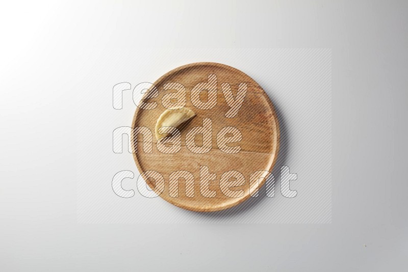 A single Sambosa on a wooden round plate on a white background