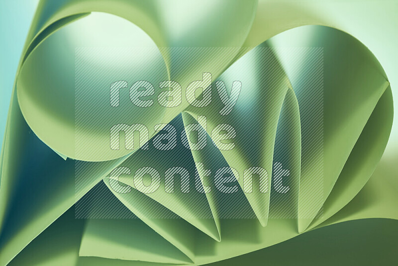 An artistic display of paper folds creating a harmonious blend of geometric shapes, highlighted by soft lighting in green tones