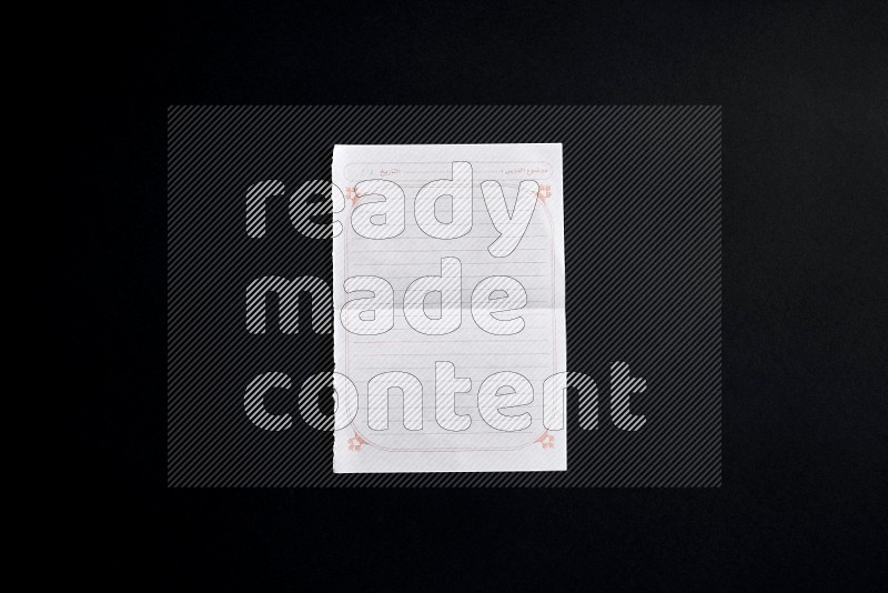 Folded notebook sheet on black background