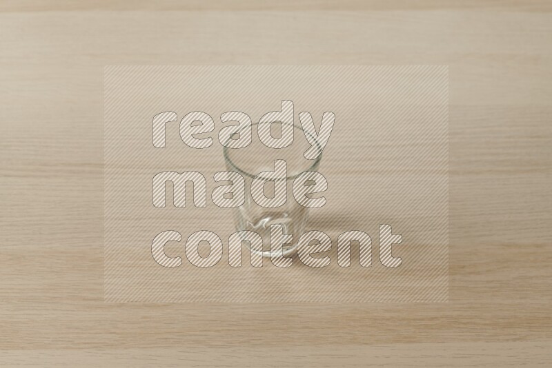 An empty glass cup on light wooden background