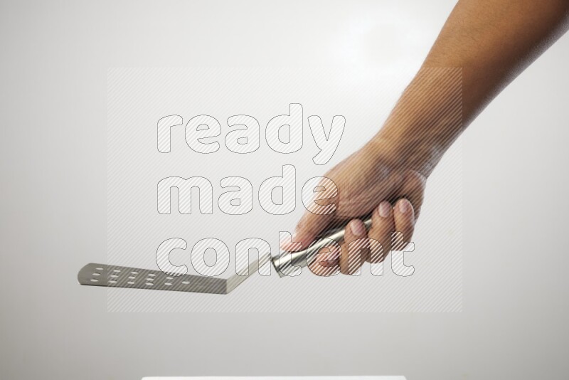Male Hand Holding Burger Flipper on white background