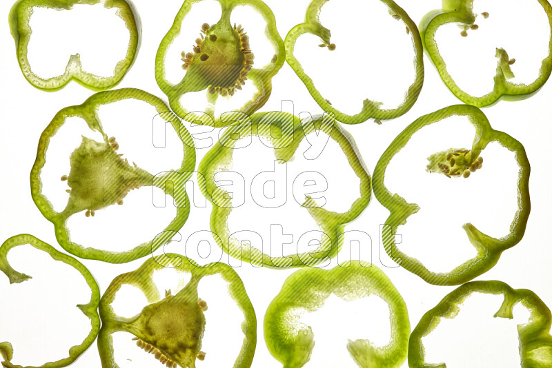 Green bell pepper slices on illuminated white background