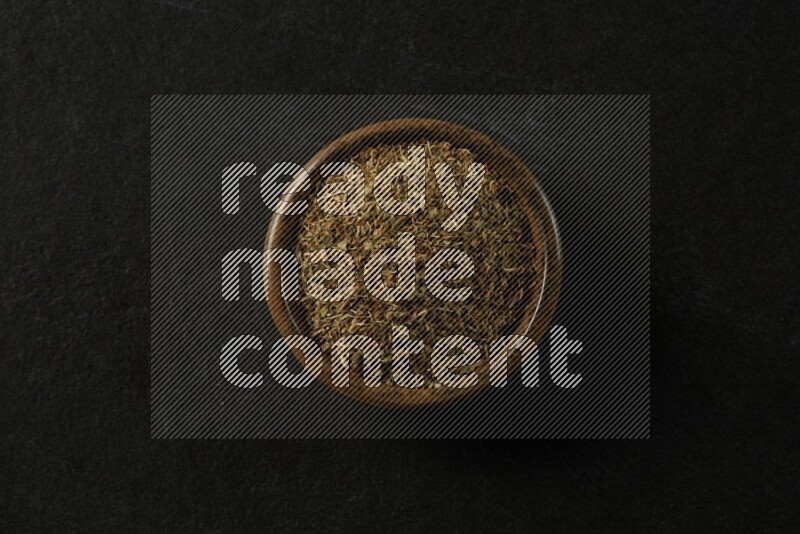 multi color round sauce bowl filled with herbs on grey textured countertop