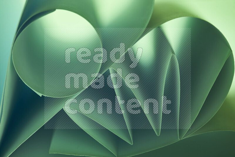 An artistic display of paper folds creating a harmonious blend of geometric shapes, highlighted by soft lighting in green tones