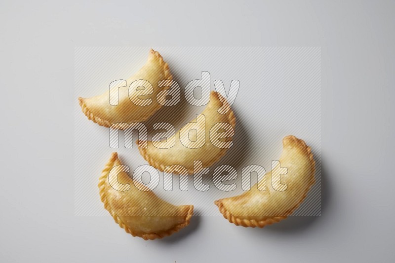 Four fried sambosa from a top angle on a white background