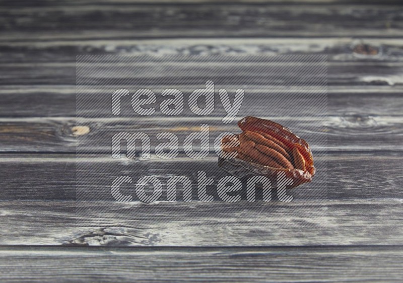 pecan stuffed madjoul date on a wooden grey background