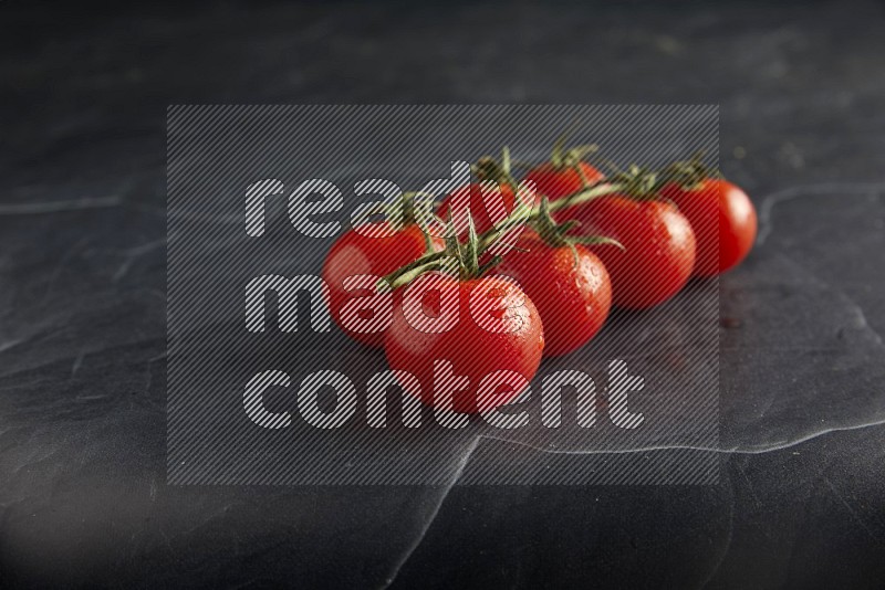 Red cherry tomato vein on a textured black slate background 45 degree