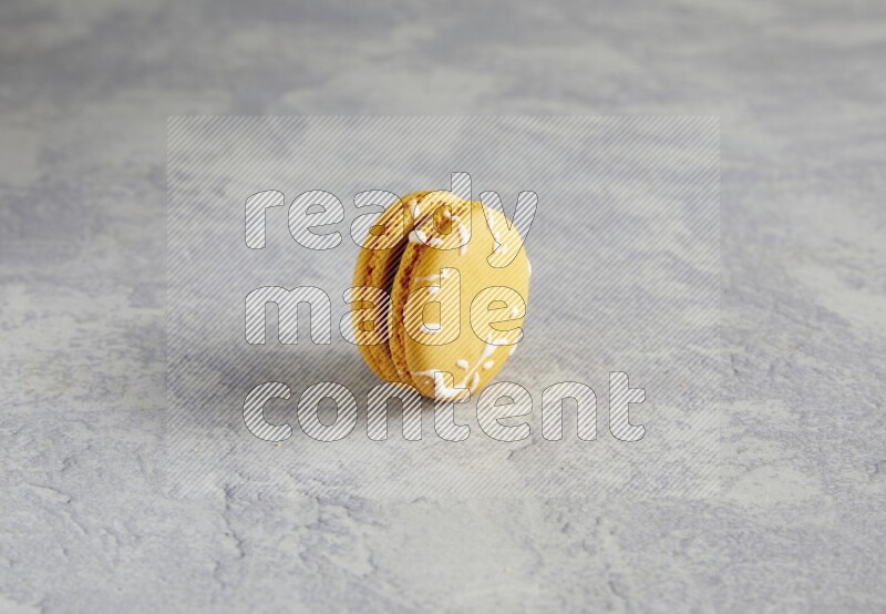 45º Shot of Yellow Piña Colada macaron on white  marble background
