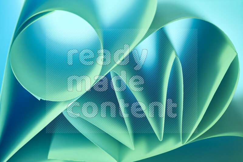An artistic display of paper folds creating a harmonious blend of geometric shapes, highlighted by soft lighting in green and blue tones