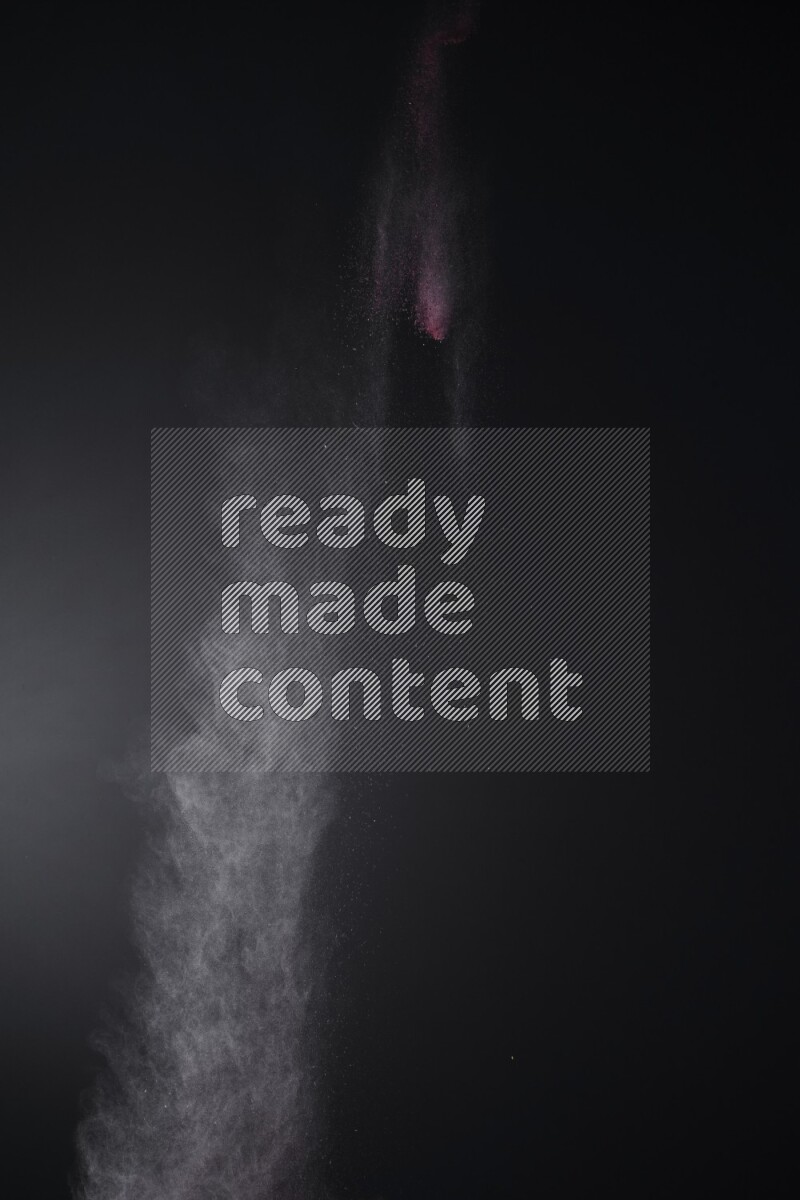 A side view of red powder explosion on black background
