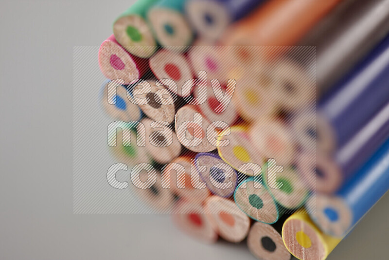 An array of colored pencils on grey background