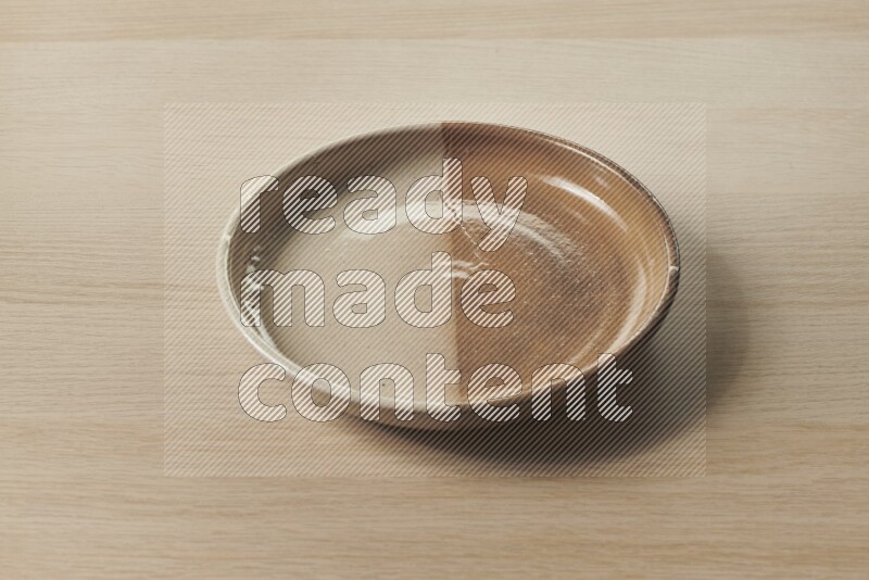 A multicolored pottery plate on light wooden background