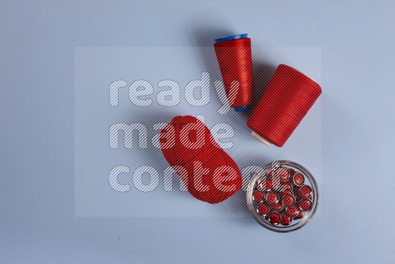 Red sewing supplies on blue background