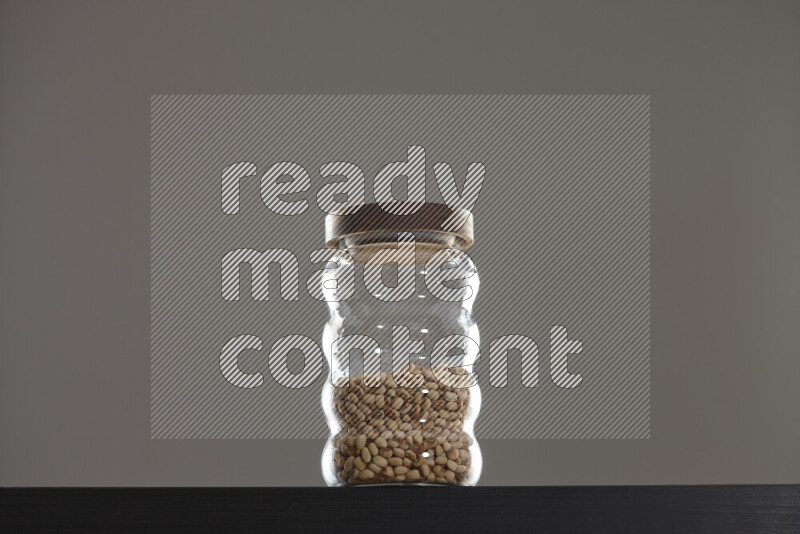 Black-eyed peas in a glass jar on black background