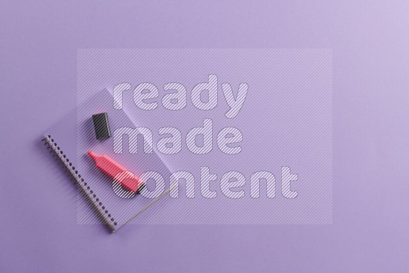 دفتر ملاحظات باللون الأرجواني مع مستلزمات مدرسية مختلفة على خلفية أرجوانية