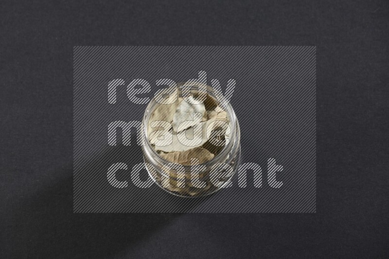 وعاء زجاجي ممتلئ بأوراق الغارعلي خلفية سوداء