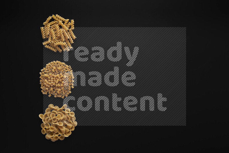 Different pasta types in 3 bunches on black background