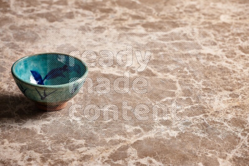 A decorative pottery bowl on beige marble background
