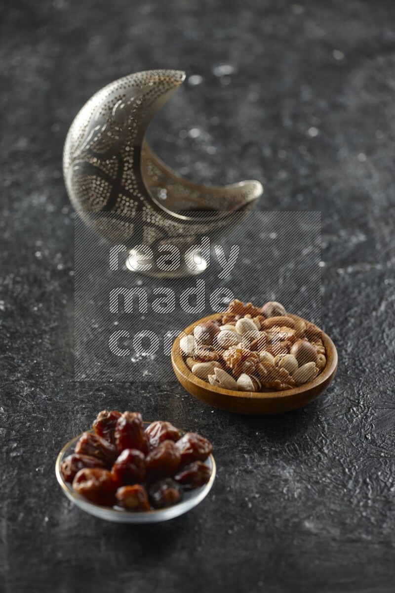 فانوس فضي مع مشروبات مختلفة وتمر ومكسرات وسبحة صلاة وقرآن على خلفية سوداء