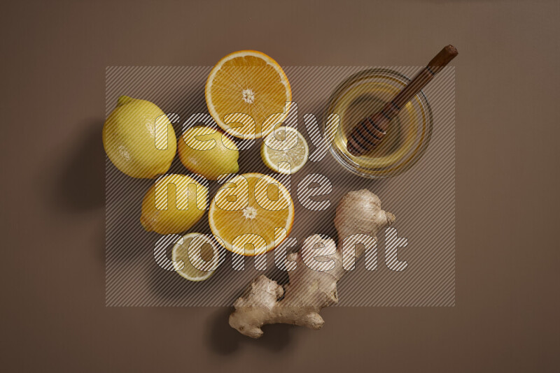 Fresh ginger root with different ingredients such as lemon, orange, honey, ground ginger on beige baackground