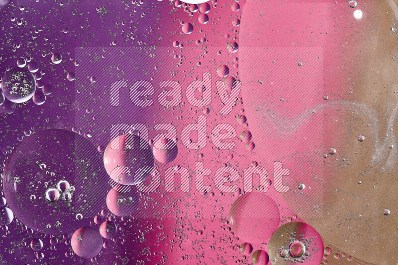 لقطات مقربة لفقاعات من الزيت على سطح الماء باللون البني والأرجواني والوردي