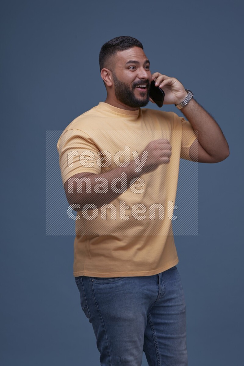 A man Calling on Blue Background wearing Orange T-shirt