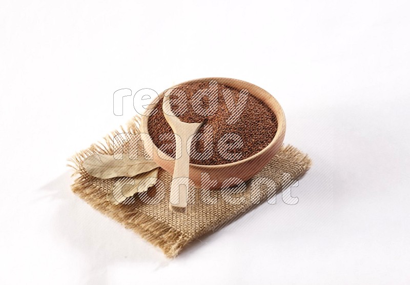 A wooden bowl and spoon full of garden cress on burlap fabric on a white flooring in different angles