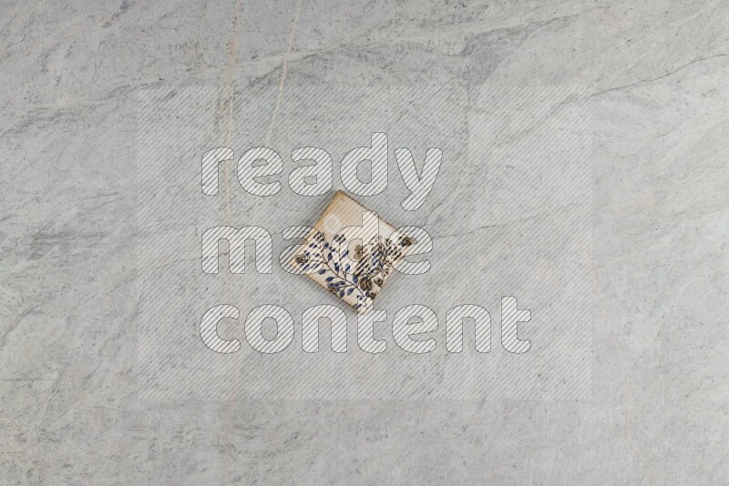 A decorative pottery coaster on grey marble background