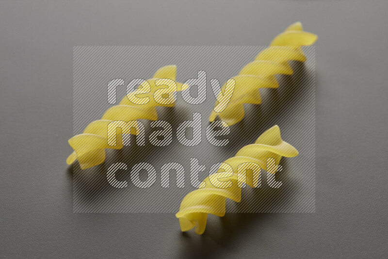 Fusilli pasta on grey background