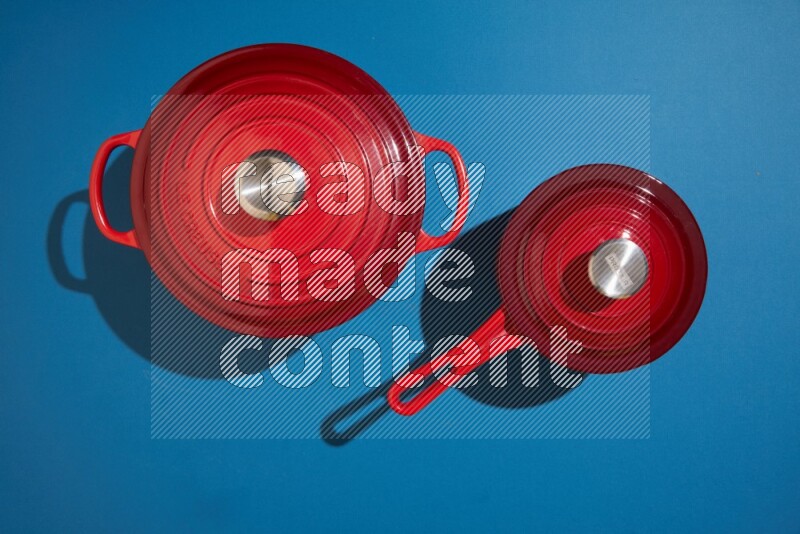 red and white pan and pot on blue background