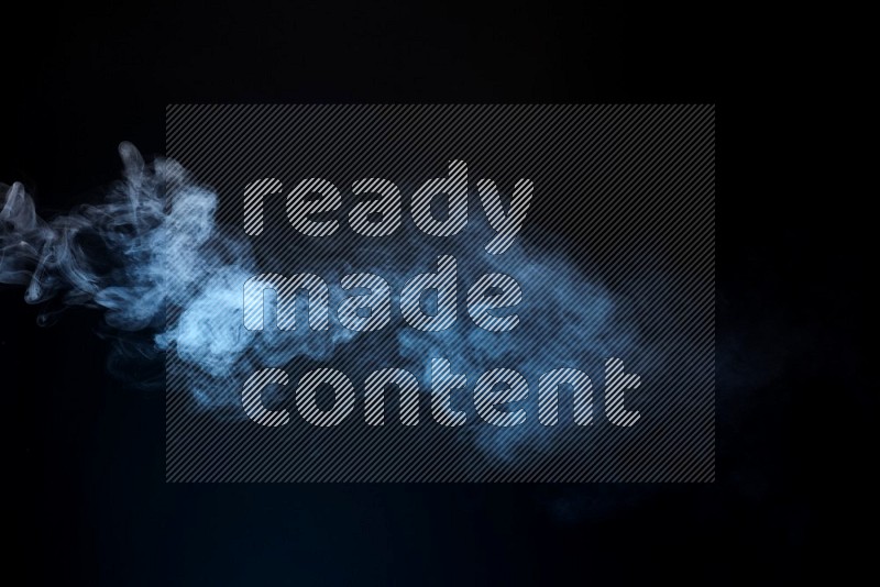 Heavy smoke in blue isolated on black background