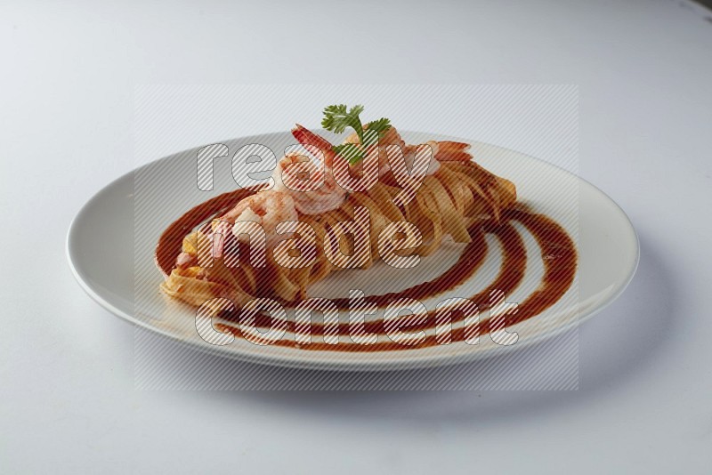 Fettuccini red sauce pasta with shrimp in a white plate on a white background
