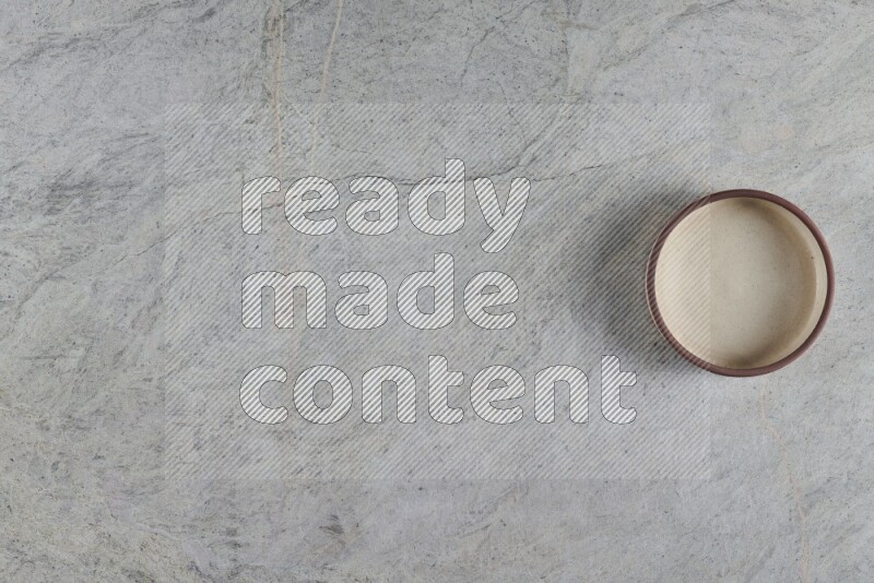 A multicolored pottery oven bowl on grey marble background