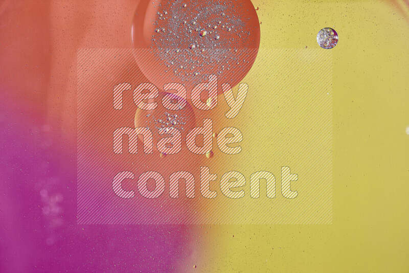 لقطات مقربة لفقاعات من الزيت على سطح الماء باللون الأصفر والبرتقالي والوردي