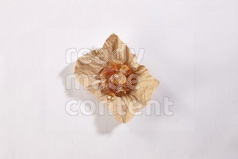 A crumpled piece of paper full of gum arabic on white flooring